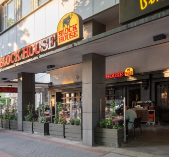 BLOCK HOUSE Hannover Am Aegi – Steakhouse mit Terrasse BLOCK HOUSE Hannover Am Aegi mit Terrasse und Gästen vor dem Steakhouse, direkt in der Nähe des Aegidientorplatz