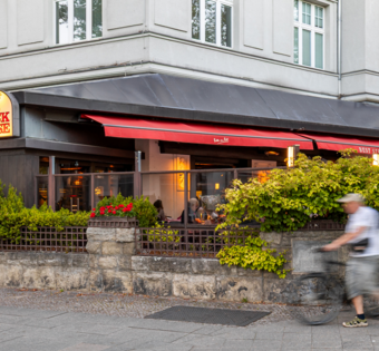 BLOCK HOUSE Berlin Theodor-Heuss-Platz – Steakhouse mit Terrasse Terrasse des BLOCK HOUSE Berlin Theodor-Heuss-Platz mit Tischen und Gästen vor dem Steakhouse
