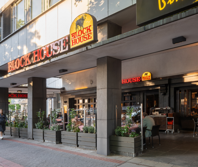 BLOCK HOUSE Hannover Am Aegi – Steakhouse mit Terrasse BLOCK HOUSE Hannover Am Aegi mit Terrasse und Gästen vor dem Steakhouse, direkt in der Nähe des Aegidientorplatz