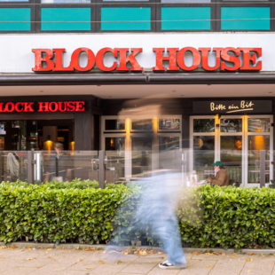 Frontalansicht des BLOCK HOUSE Hamburg Wandsbek mit Terrasse und Eingangsbereich