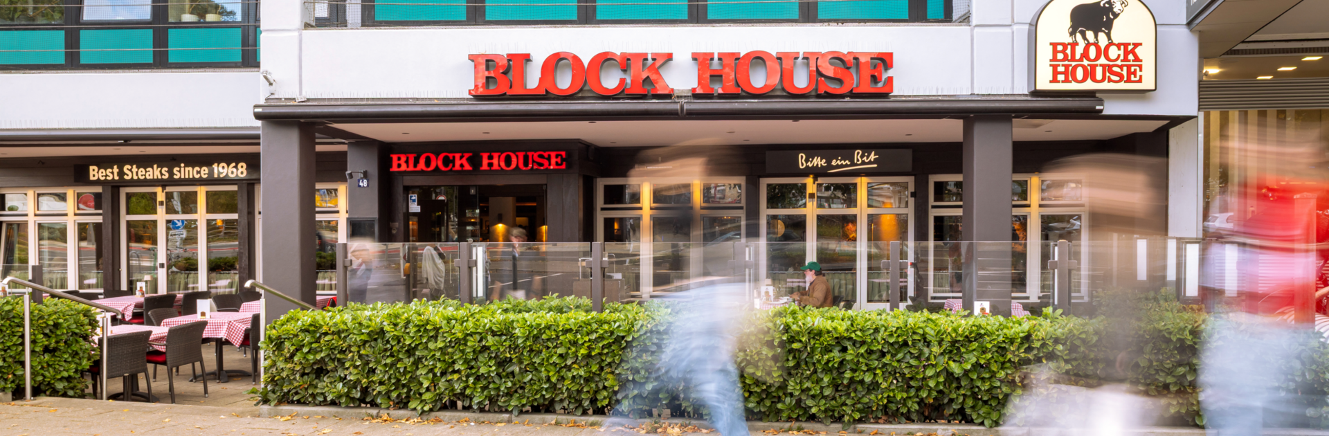 Frontalansicht des BLOCK HOUSE Hamburg Wandsbek mit Terrasse und Eingangsbereich