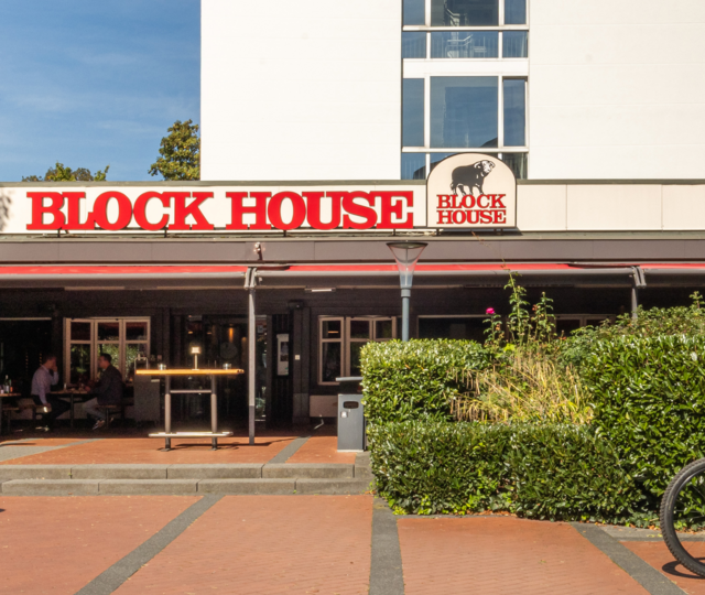 Außenansicht des BLOCK HOUSE Frankfurt Westend mit Terrasse, Eingang zum Steakhouse und Gästen im Außenbereich