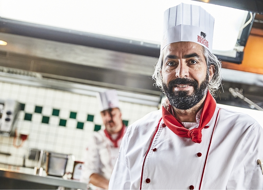 Lächelnder Koch in der Küche eines BLOCK HOUSE Restaurants