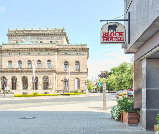 Blick an der Terrasse des BLOCK HOUSE Restaurants Braunschweig vorbei auf das Staatstheater in Braunschweig