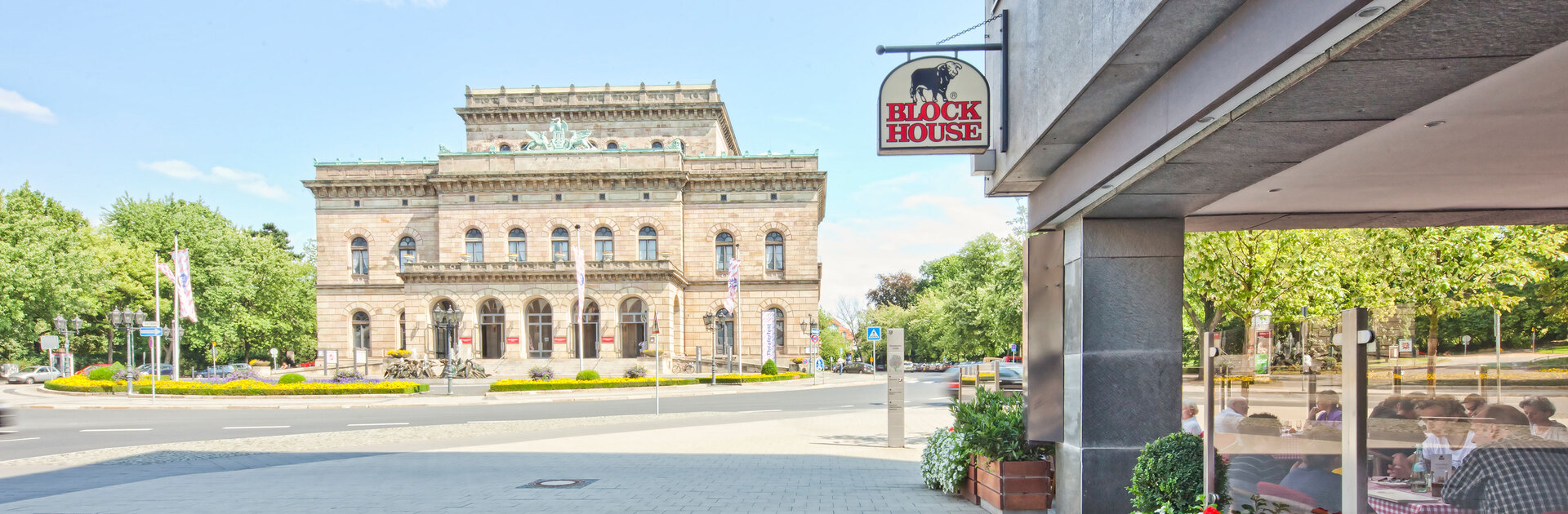 Blick an der Terrasse des BLOCK HOUSE Restaurants Braunschweig vorbei auf das Staatstheater in Braunschweig