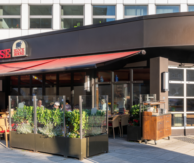 Außenansicht des BLOCK HOUSE Hannover am Thielenplatz mit Terrasse und Gästen im Außenbereich.