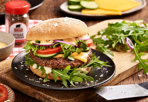 BLOCK HOUSE Bio-Burger mit Rindfleischpatty auf einem Teller serviert