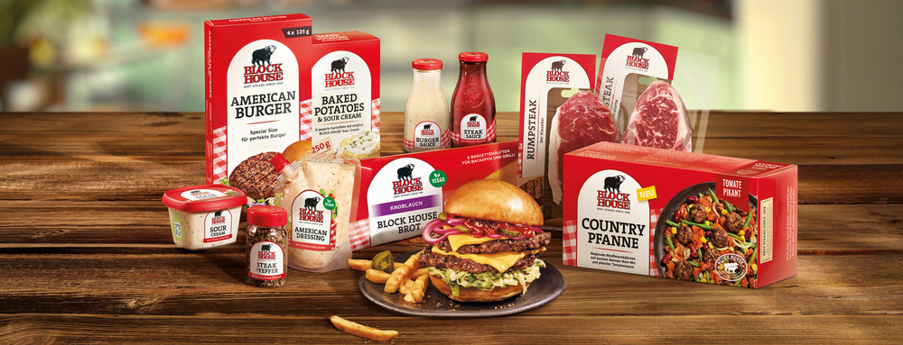 BLOCK HOUSE Steakhouse Produkte für zuhause mit Burger, Steaks, Saucen und Beilagen auf einem Tisch angerichtet