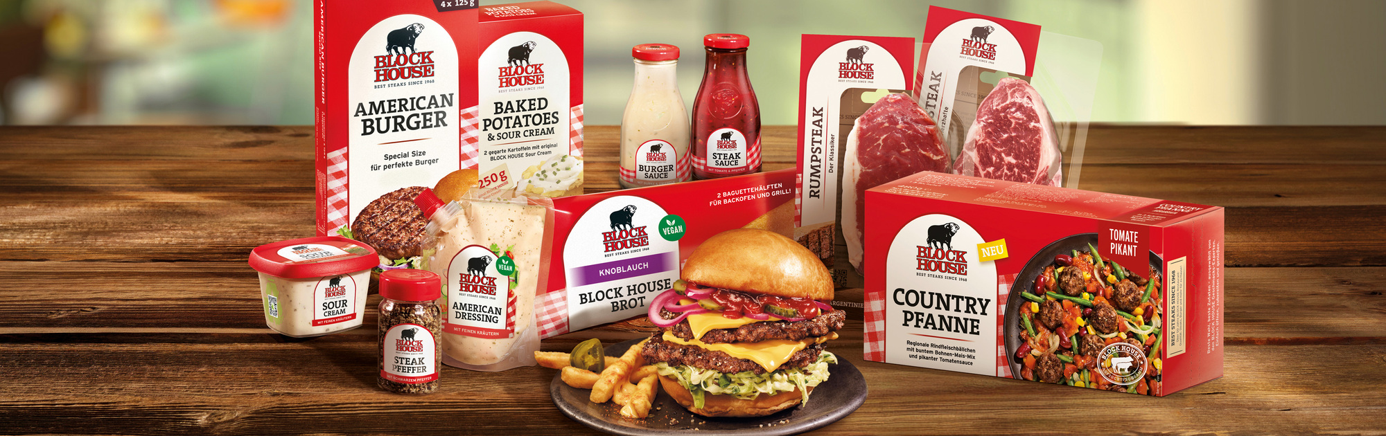 BLOCK HOUSE Steakhouse Produkte für zuhause mit Burger, Steaks, Saucen und Beilagen auf einem Tisch angerichtet