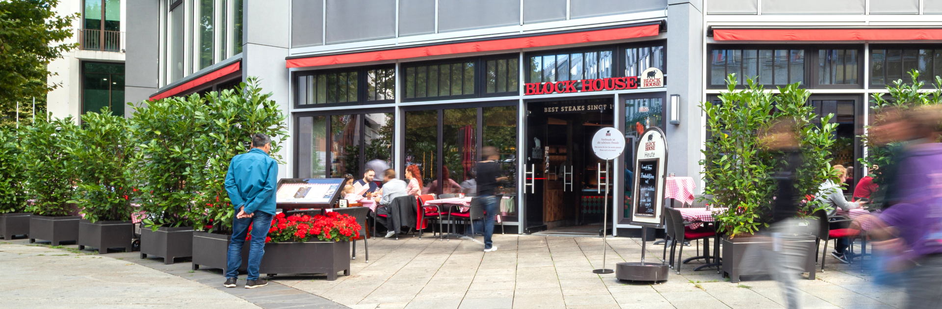 BLOCK HOUSE Stuttgart Königstraße Außenansicht des BLOCK HOUSE Stuttgart Königstraße mit Terrasse und Gästen vor dem Restaurant.