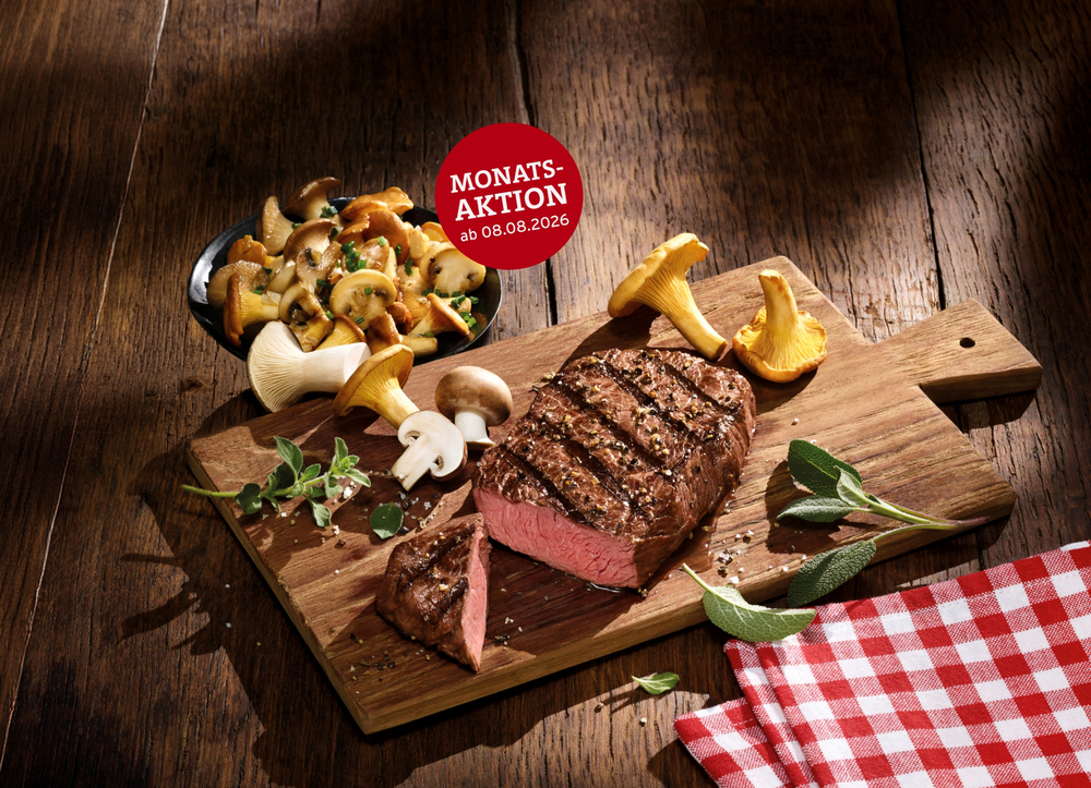 Monatsaktion BLOCK HOUSE 08.08. – 06.09.2026 Ein saftig gegrilltes Rumpsteak von BLOCK HOUSE liegt auf einem Holzbrett, umgeben von frischen Kräutern, verschiedenen Pilzen wie Pfifferlingen, Kräuterseitlingen und Champignons.