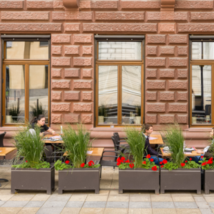 BLOCK HOUSE Frankfurt am Börsenplatz Außenansicht des BLOCK HOUSE Frankfurt am Börsenplatz mit Terrasse, begrüntem Außenbereich und Gästen vor dem Restaurant.