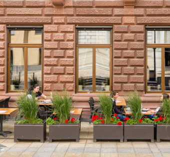 BLOCK HOUSE Frankfurt am Börsenplatz Außenansicht des BLOCK HOUSE Frankfurt am Börsenplatz mit Terrasse, begrüntem Außenbereich und Gästen vor dem Restaurant.