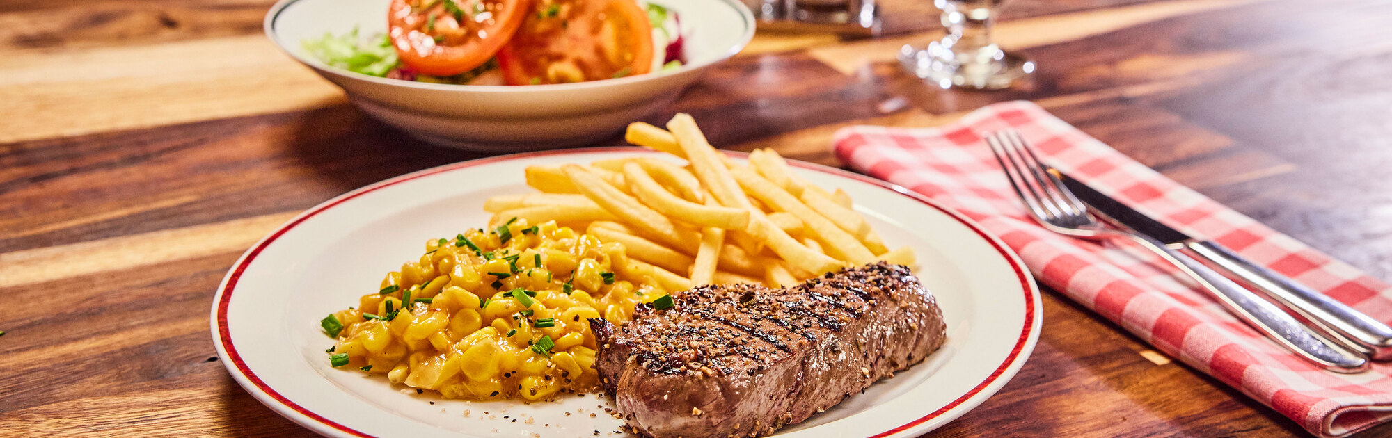 Steak, Mais und Pommes frites auf einem Teller in einem BLOCK HOUSE