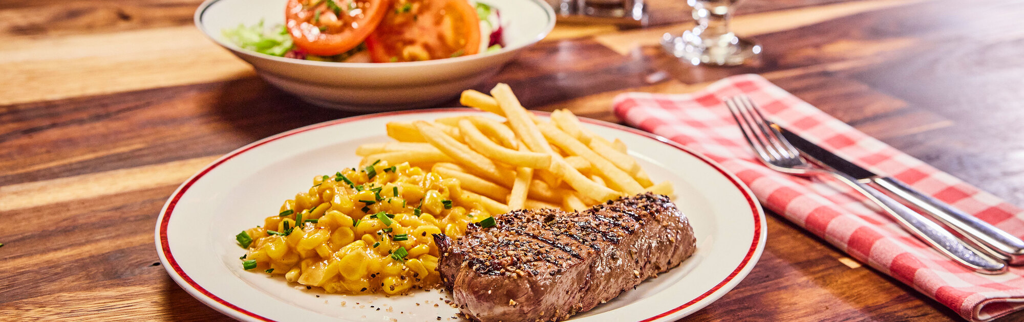 Steak, Mais und Pommes frites auf einem Teller in einem BLOCK HOUSE.