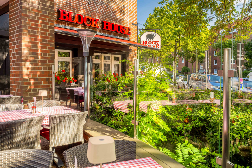 BLOCK HOUSE Hamburg Eidelstedt – Steakhouse mit Terrasse Terrasse vor dem BLOCK HOUSE Hamburg Eidelstedt mit Tischen und rot-weiß karierten Tischdecken vor dem Restaurant