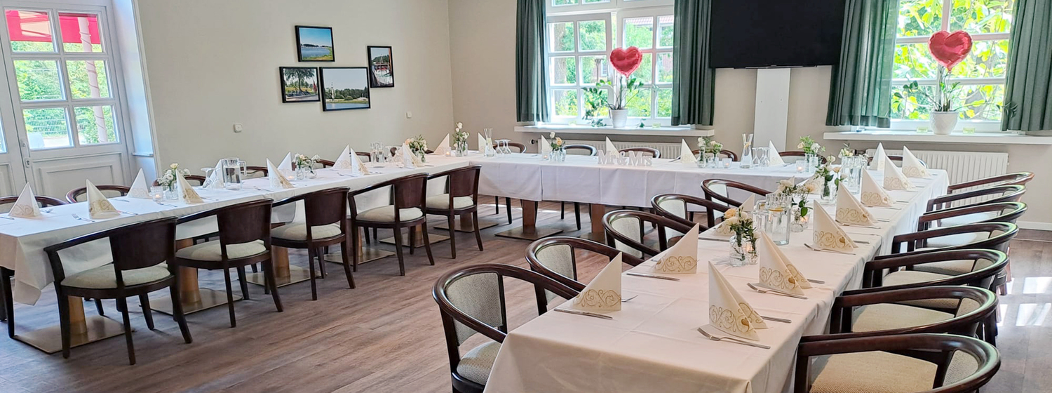 Veranstaltungsraum im Gasthaus Block, hell und freundlich dekoriert für eine Hochzeit mit weißen Tischdecken, Blumen und festlich gefalteten Servietten.