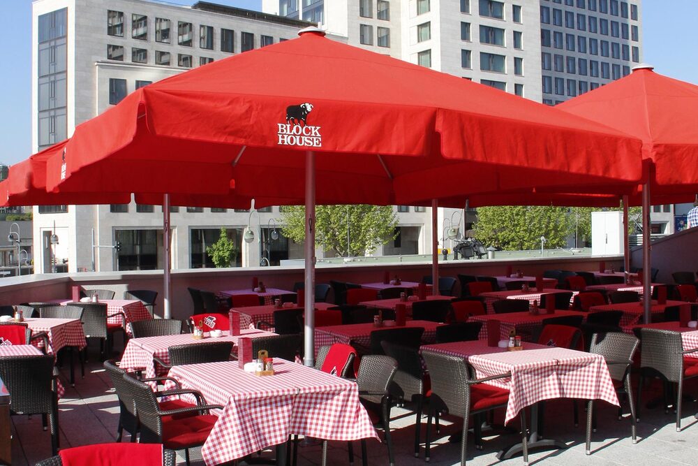BLOCK HOUSE Berlin Zoo Palast Terrasse mit Sonnenschirmen des BLOCK HOUSE Restaurants am Zoo Palast in Berlin
