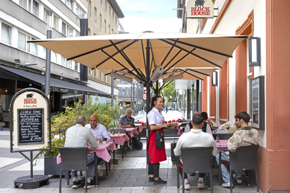 BLOCK HOUSE Mannheim Terrasse des BLOCK HOUSE Mannheim mit Gästen und Servicekraft im Außenbereich.