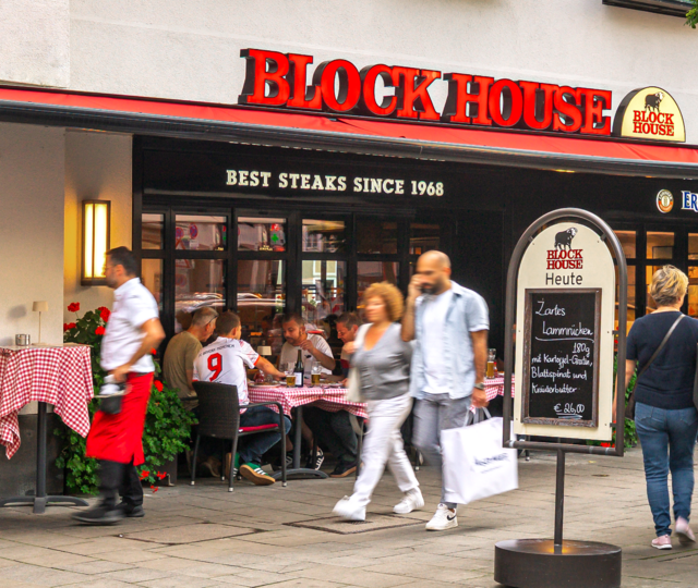 Außenansicht des BLOCK HOUSE München am Rindermarkt mit Gästen und Servicepersonal vor dem Restaurant.
