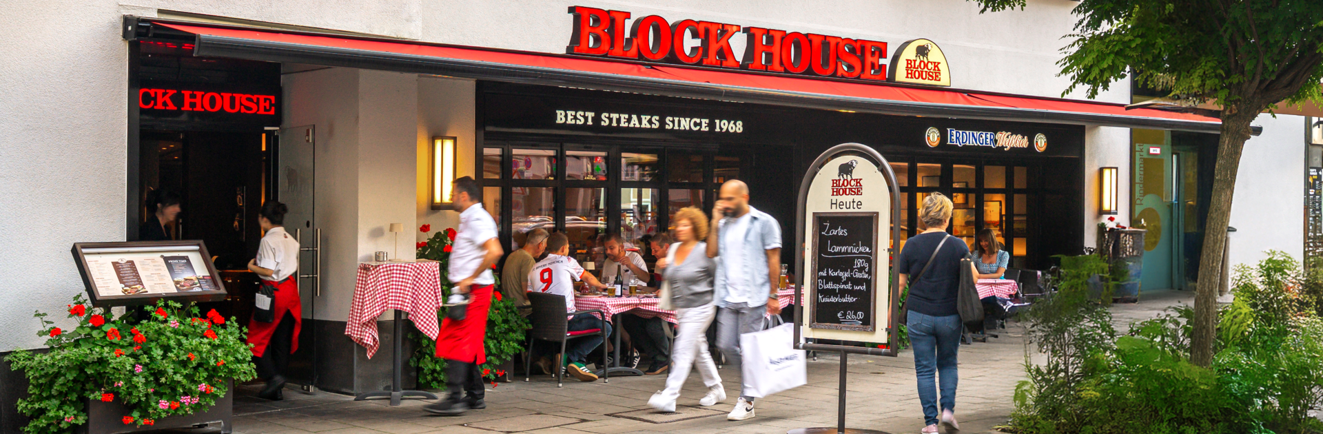 Außenansicht des BLOCK HOUSE München am Rindermarkt mit Gästen und Servicepersonal vor dem Restaurant.
