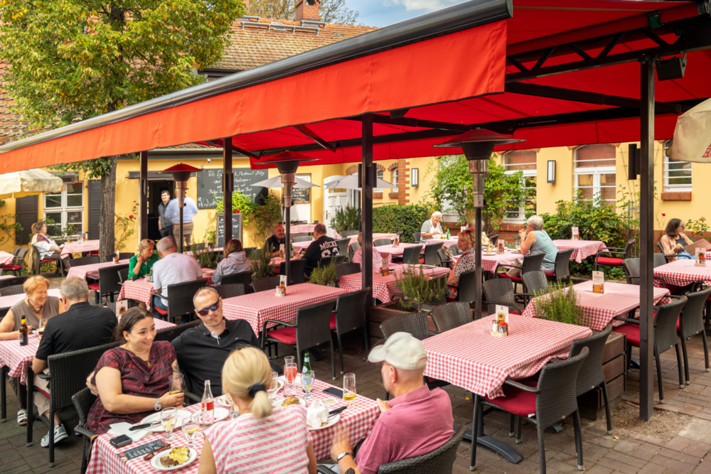 BLOCK HOUSE Berlin Zehlendorf Terrasse des BLOCK HOUSE Restaurants Zehlendorf in Berlin. Gedeckte Tische mit rot-karierten Tischdecken