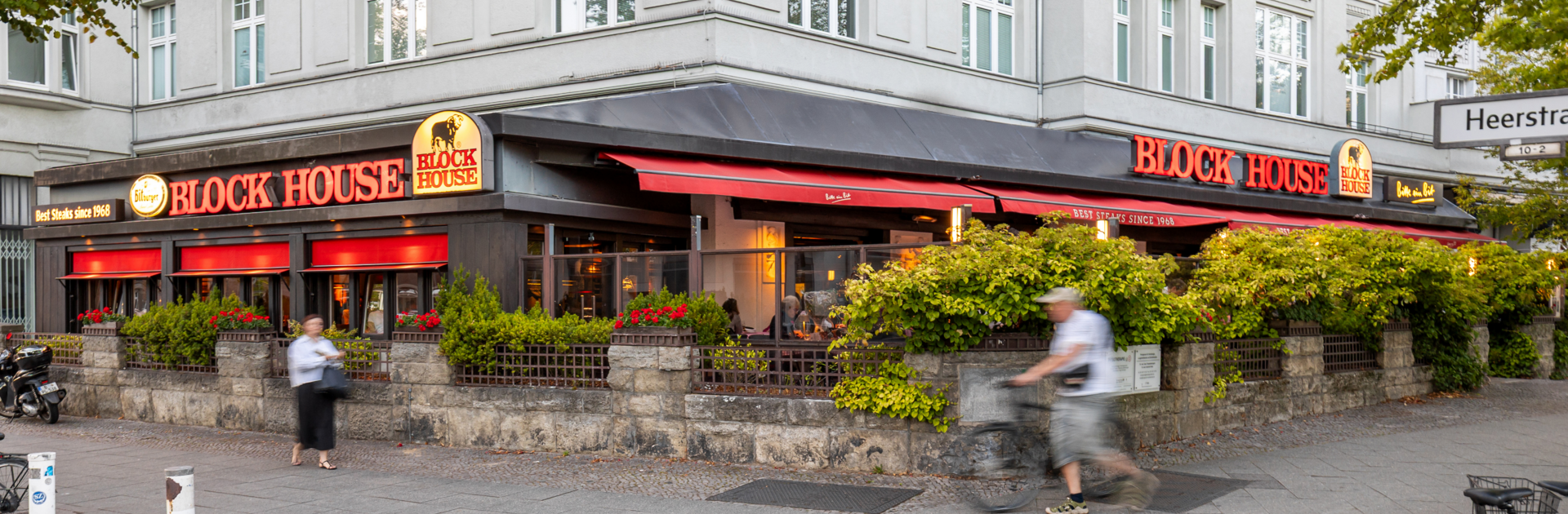Terrasse des BLOCK HOUSE Berlin Theodor-Heuss-Platz mit Tischen und Gästen vor dem Steakhouse