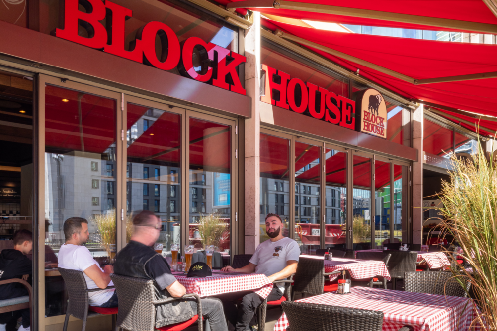Gäste speisen auf der sonnengeschützten Terrasse des BLOCK HOUSE Frankfurt Europa-Passage