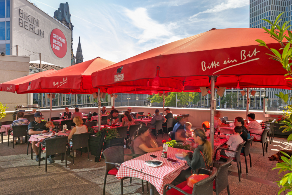BLOCK HOUSE Berlin Zoo Palast Terrasse mit Sonnenschirmen des BLOCK HOUSE Restaurants am Zoo Palast in Berlin