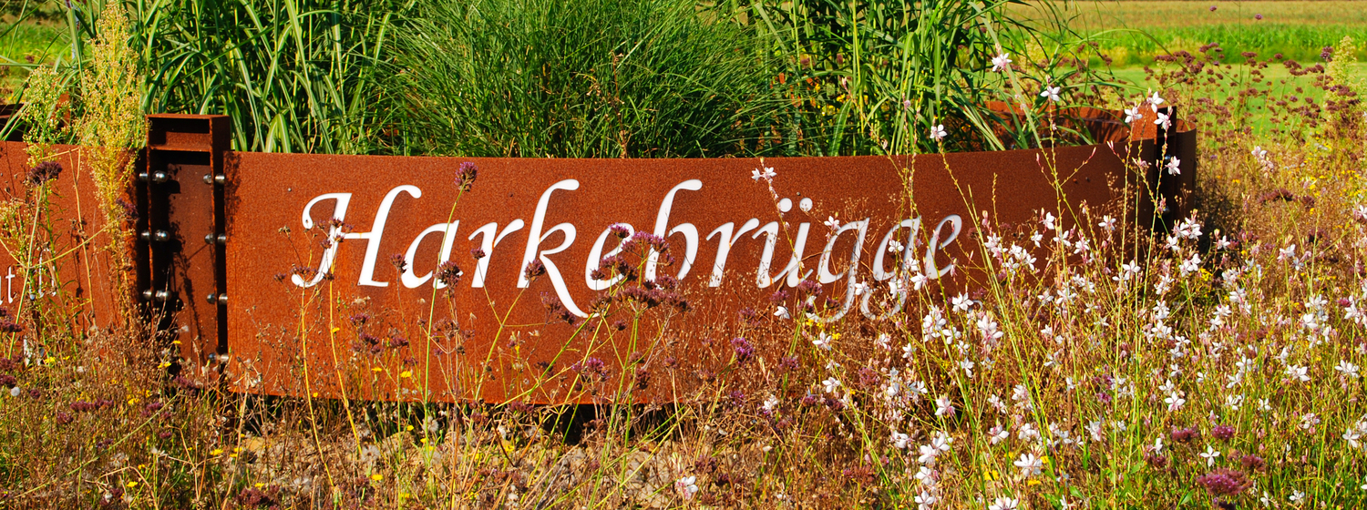 Schild mit der Aufschrift "Harkebrügge" im Grünen