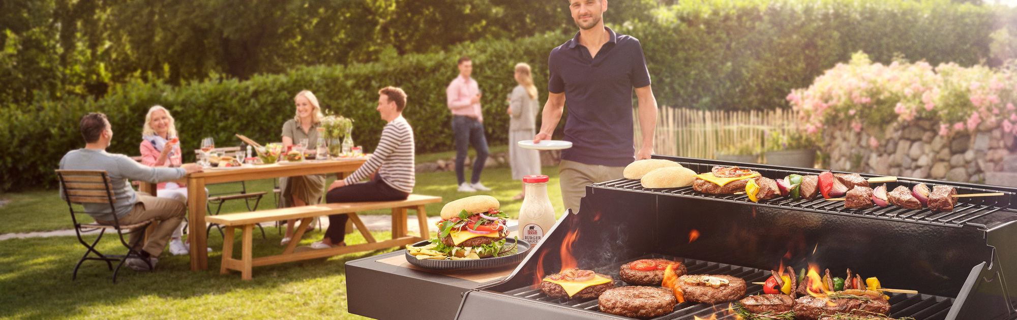 Grillparty mit brutzelndem Fleisch auf einem großen Grill