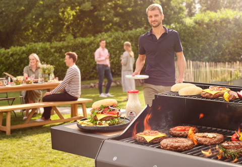 Grillparty mit brutzelndem Fleisch auf einem großen Grill