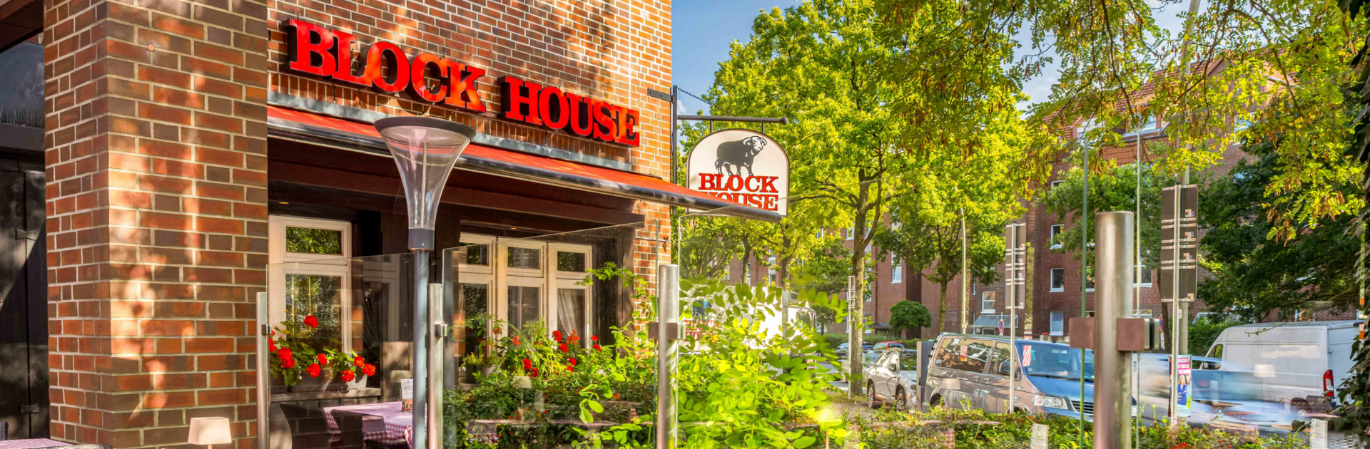 BLOCK HOUSE Hamburg Eidelstedt – Steakhouse mit Terrasse Terrasse vor dem BLOCK HOUSE Hamburg Eidelstedt mit Tischen und rot-weiß karierten Tischdecken vor dem Steakhouse